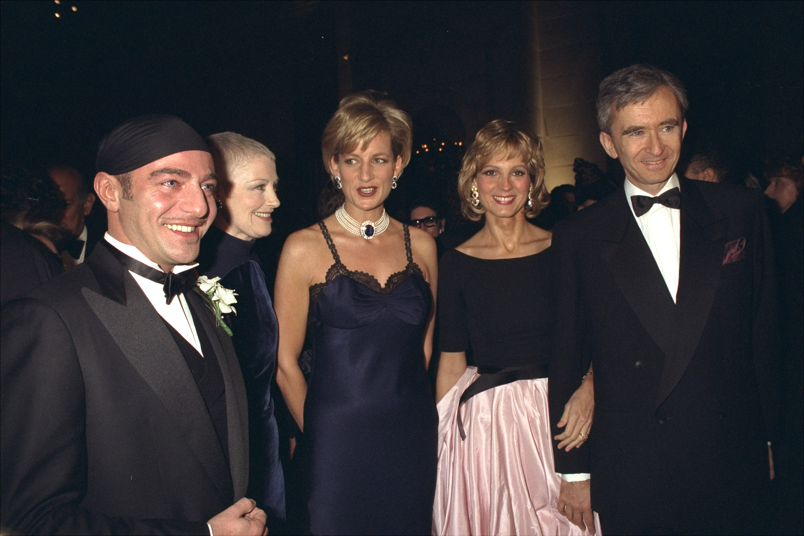 Princess Diana posing with John Galliano and guests at the 1996 Met Gala