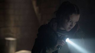 Ellie (Bella Ramsey) searching a building with her flashlight in The Last Of Us episode 3