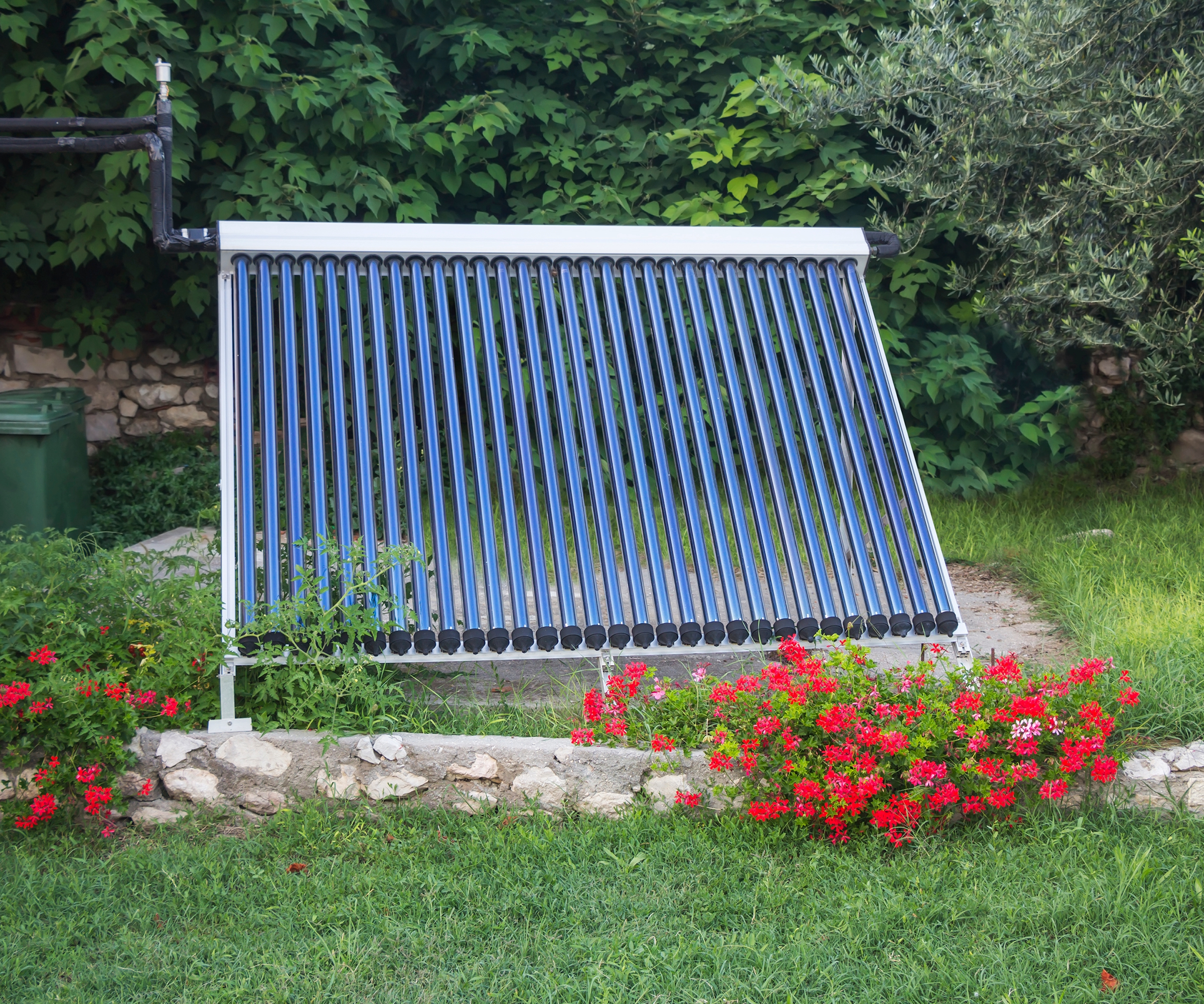 Solar thermal panels on grass by flower bed