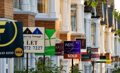 House prices as represented by 'for sale' and 'to let' signs on a terrace of properties
