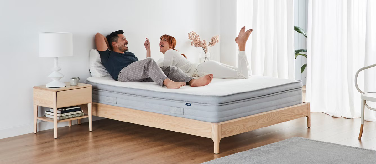 The Ecosa Pure mattress in a bright airy bedroom, with two people relaxing on the bed