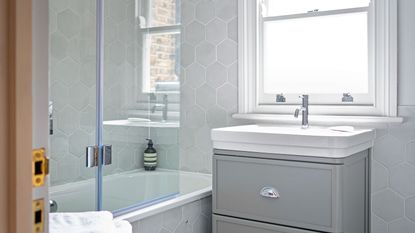 grey bathroom with tile and under sink storage