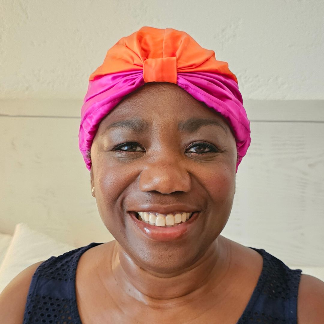 Joyce Connor pictured wearing the x silk hair wrap, tied around her hair and smiling to the camera