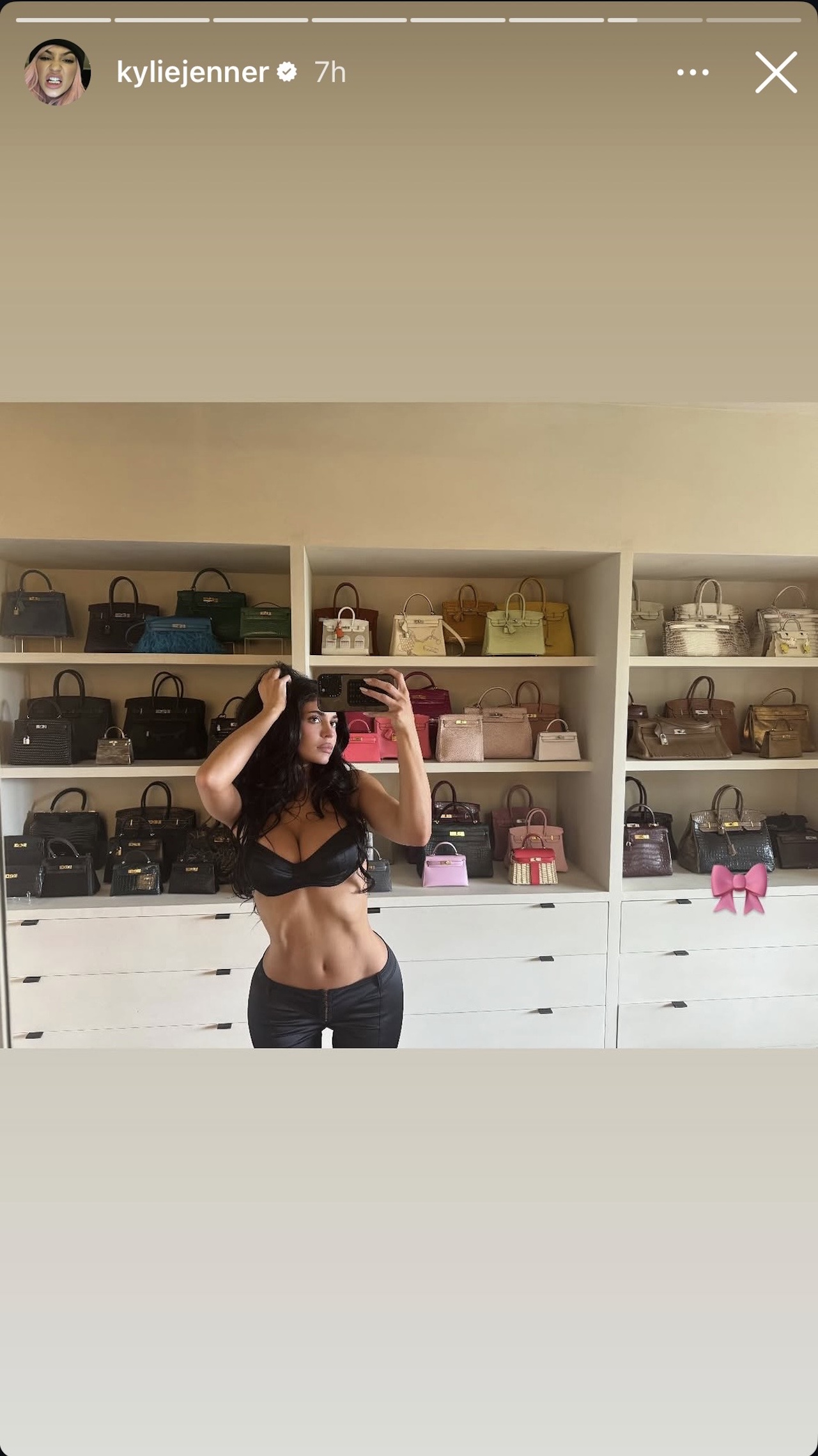 Kylie Jenner stands in front of a wall of Birkin bags.