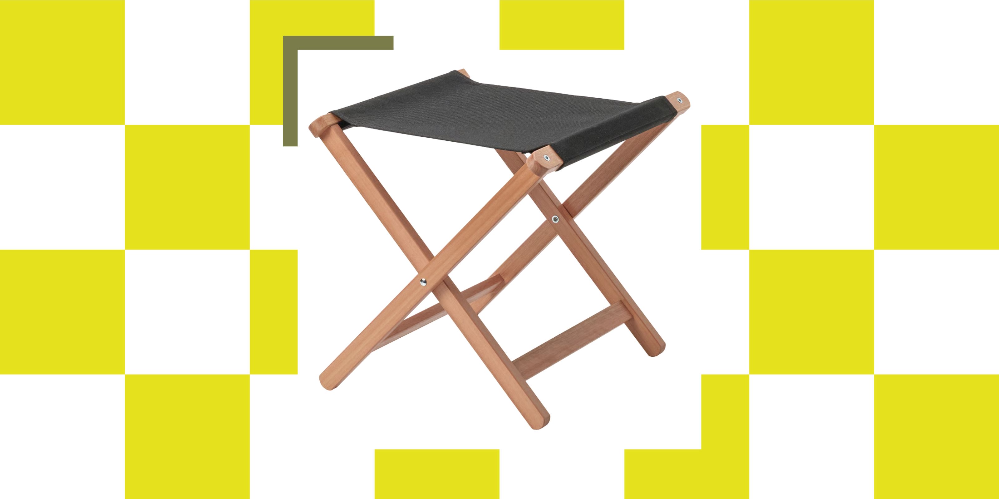A folding stool with wooden legs and grey canvas on a green and white background.
