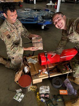 military people smile next to recovered cargo supplies.