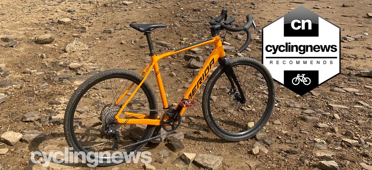 The Merida eSilex 600 on a rocky beach, overlaid with &#039;recommends&#039; badge