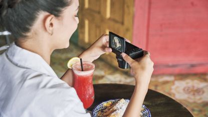A woman taking a picture of her food using the best compact camera