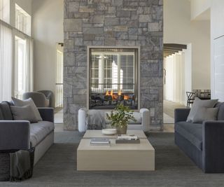living room with gray furniture and fire lit