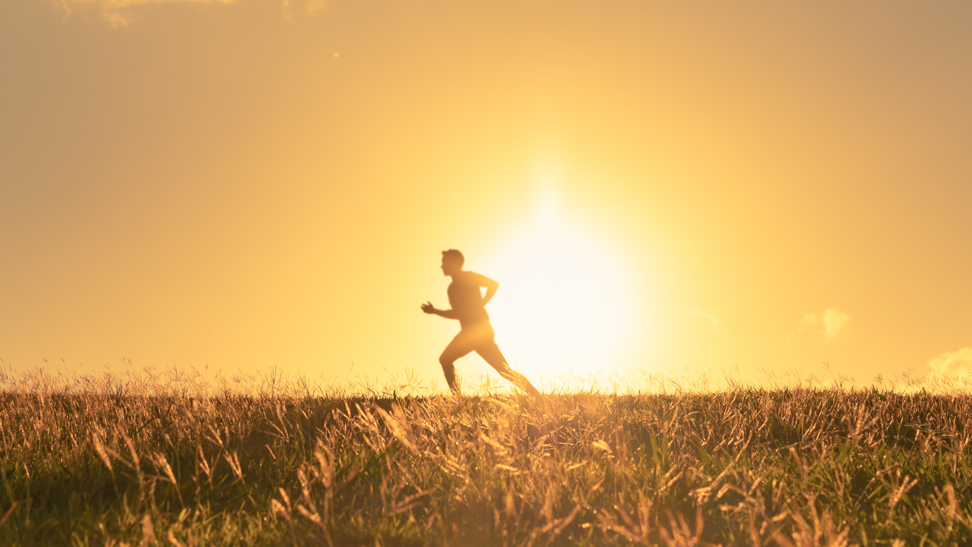 A man running outside with the sun shining