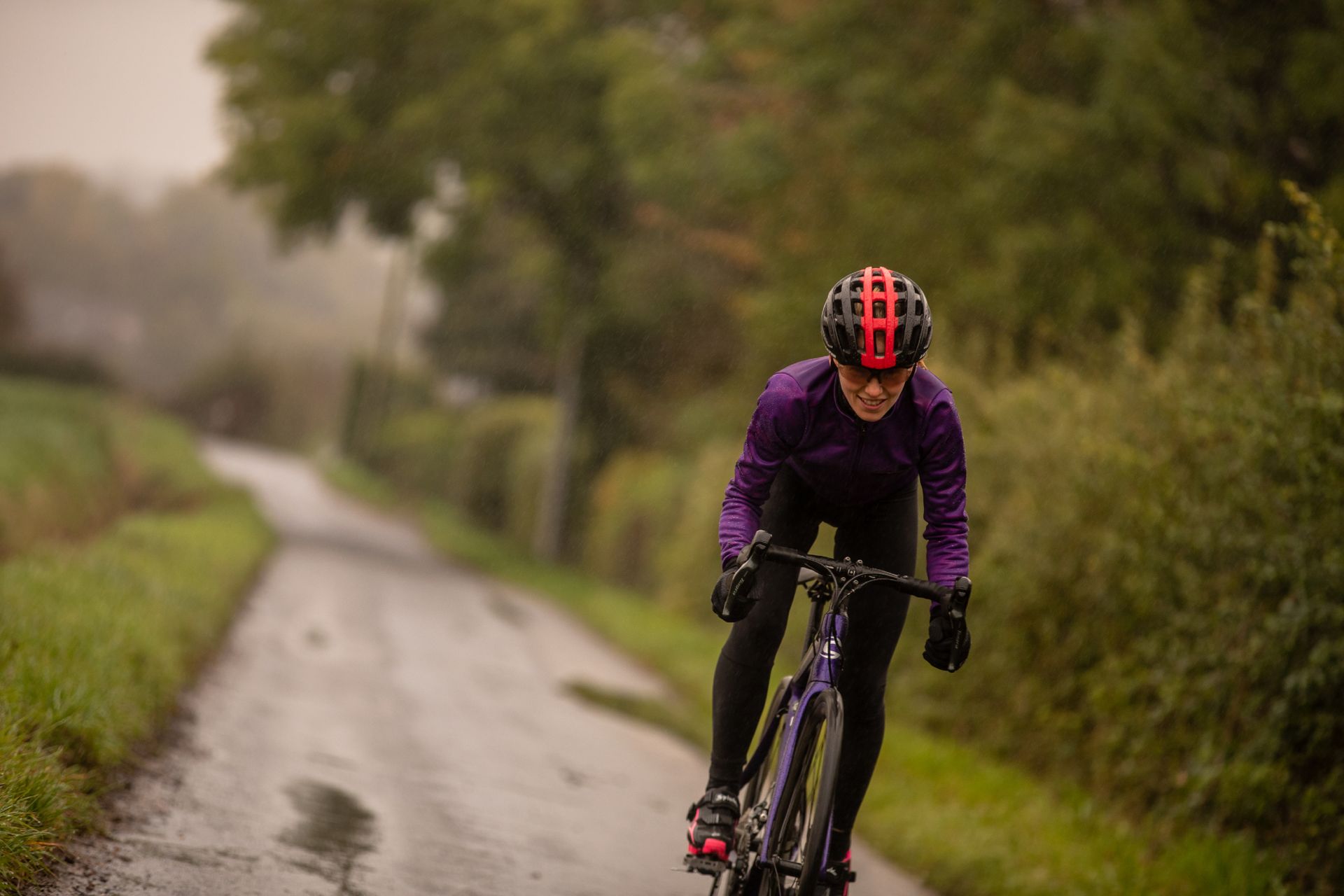 Image shows a small adult cyclist riding a bike