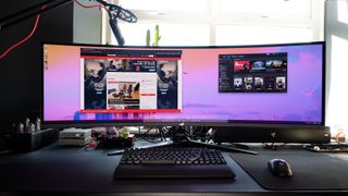 The Asus ROG Swift OLED PG49WCD set up on a gaming desk.