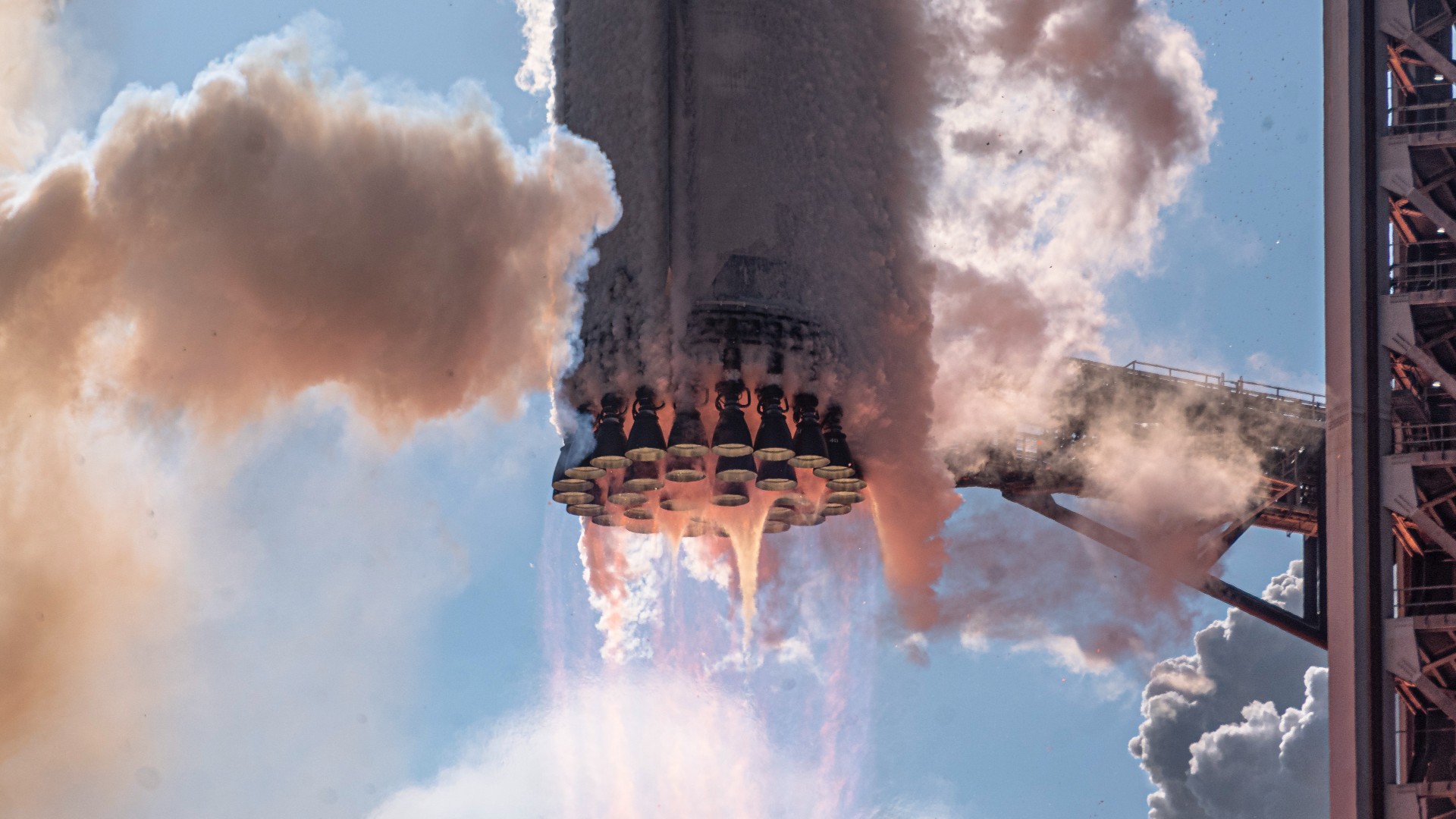 a large silver rocket launches above a plume of fire