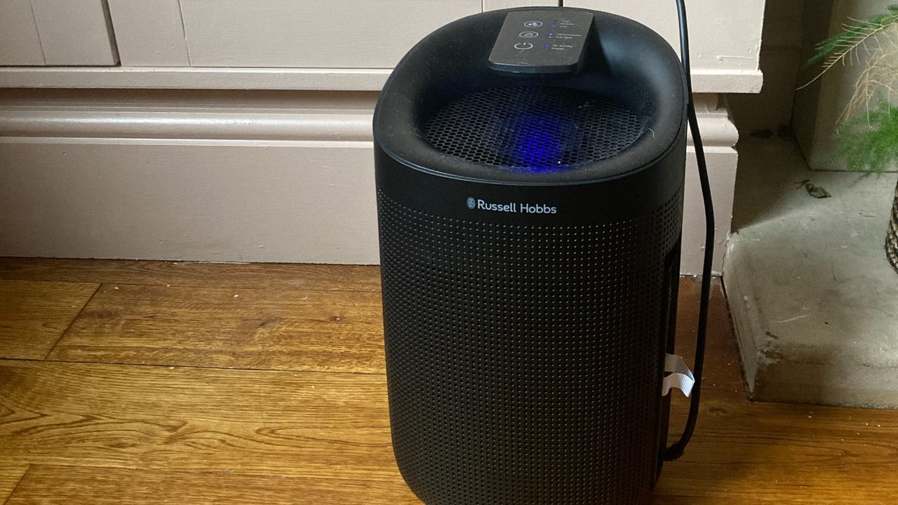 Black dehumidifier on a wooden floor being used during testing at home to qualify it as our pick of one of the best dehumidifiers