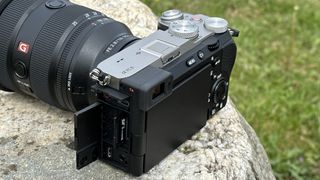 Côté de l'appareil photo sans miroir Sony A7C II à l'extérieur sur un rocher avec l'objectif Sony FE 16-35mm F2.8 GM II monté