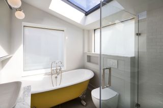 a loft conversion bathroom suite with windows and a roof light