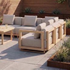 Furniture123's 6 Seater Beige Aluminium Wood Effect Garden Sofa with Matching Coffee Table on a sunny patio