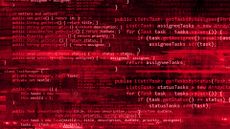 Zero-day exploit concept image showing red-colored binary code on a computer screen, blurred code and user alerts. 