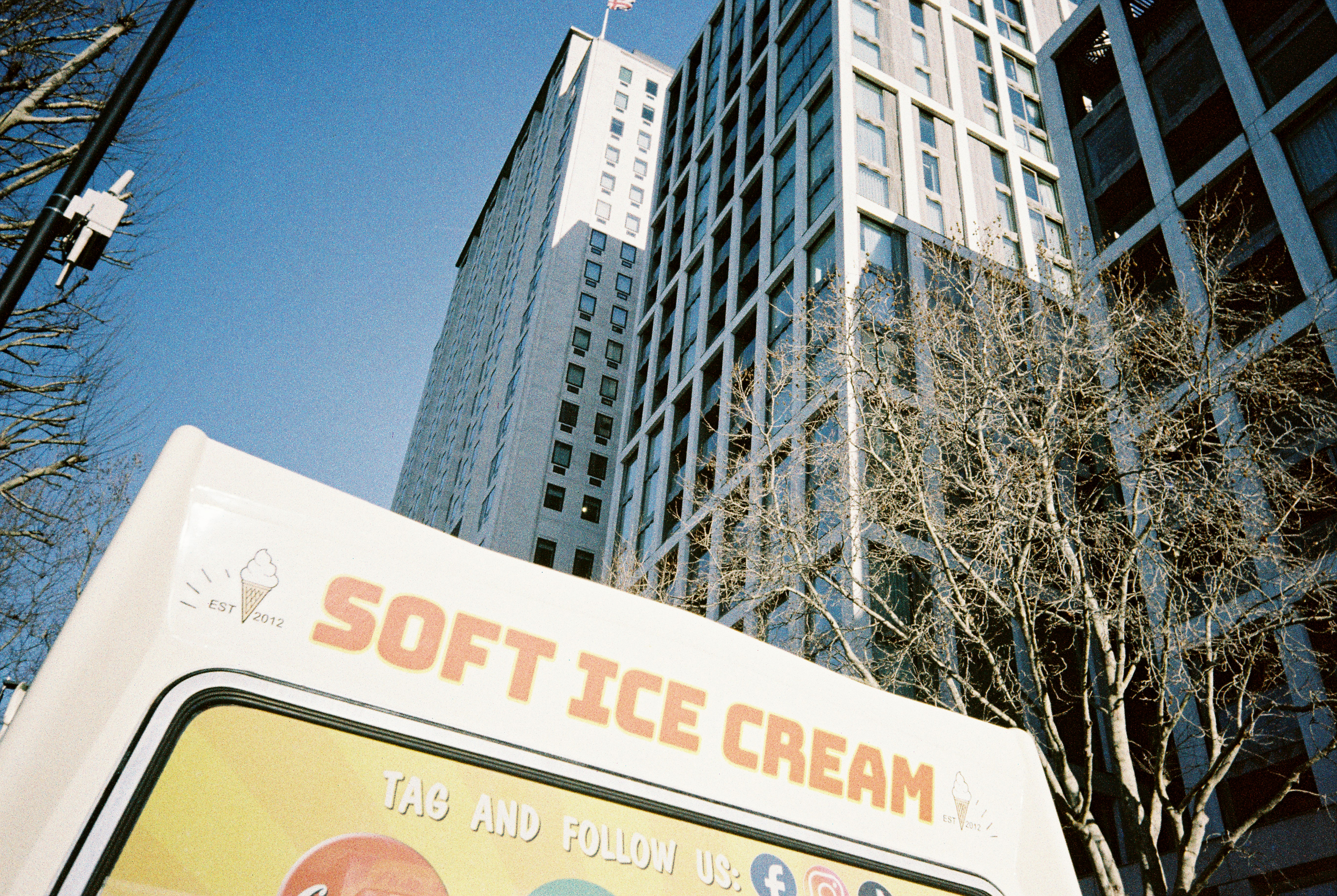 Sample photograph taken with Kodak Snapic A1 showing ice cream van top in foreground and tall buildings in background