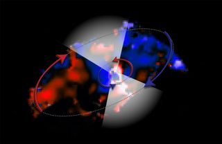 This ALMA image shows two disks of gas moving in opposite directions around a black hole in the galaxy NGC 1068. The colors represent the motion of the gas: blue is material moving toward us, red is moving away. The white triangles show the accelerated gas that is expelled from the inner disk – forming a thick, obscuring cloud around the black hole.