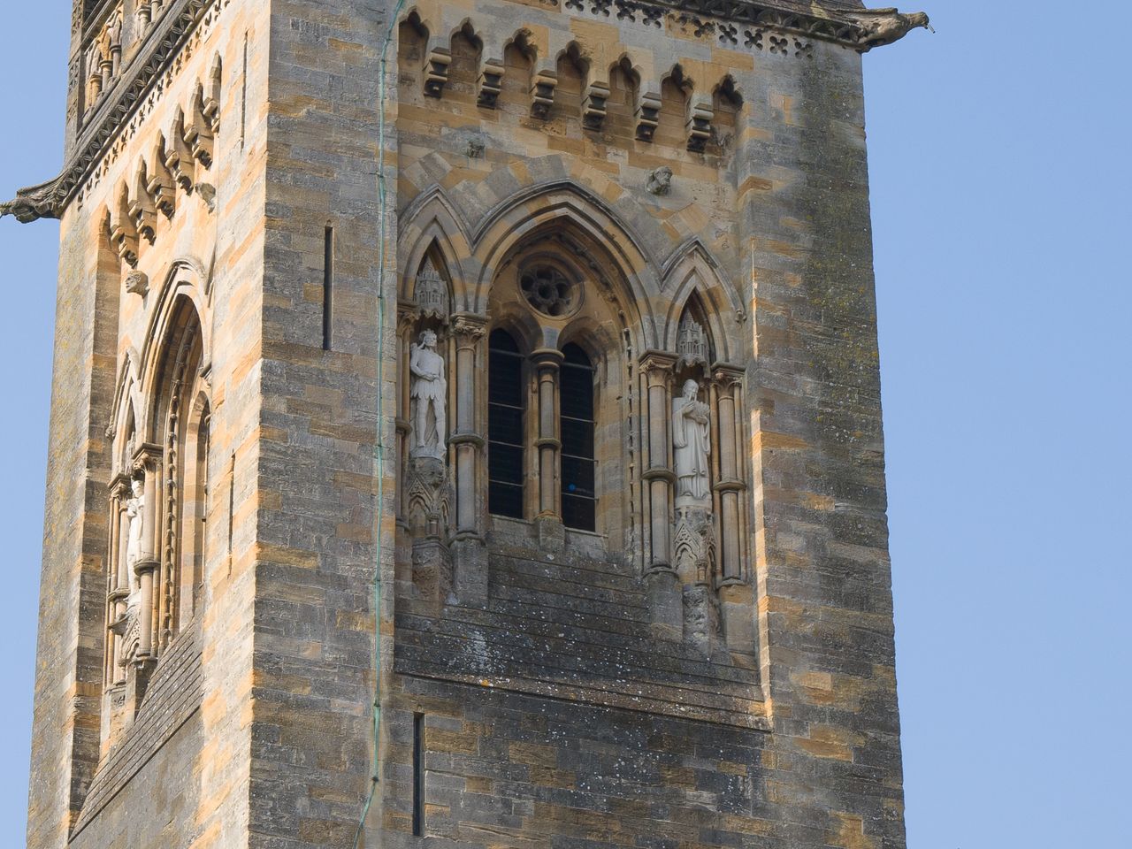 A cropped photo of a church steeple against a blue sky