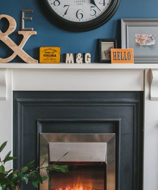 Living room with blue walls and black fireplace and wall clock