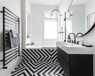 A monochrome bathroom with optical illusion tiles and a black radiator