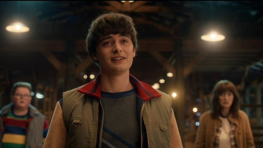 Noah Schnapp standing in front of Jake Connelly and Winona Ryder in Stranger Things Season 5