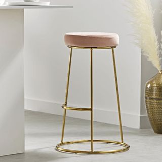 room with white walls golden bar stool and shelf on wall
