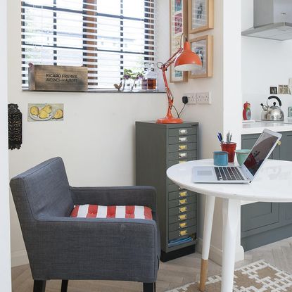 room with armchair and laptop on white table