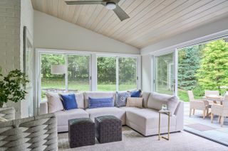 Sunroom with sectional sofa and vaulted ceiling
