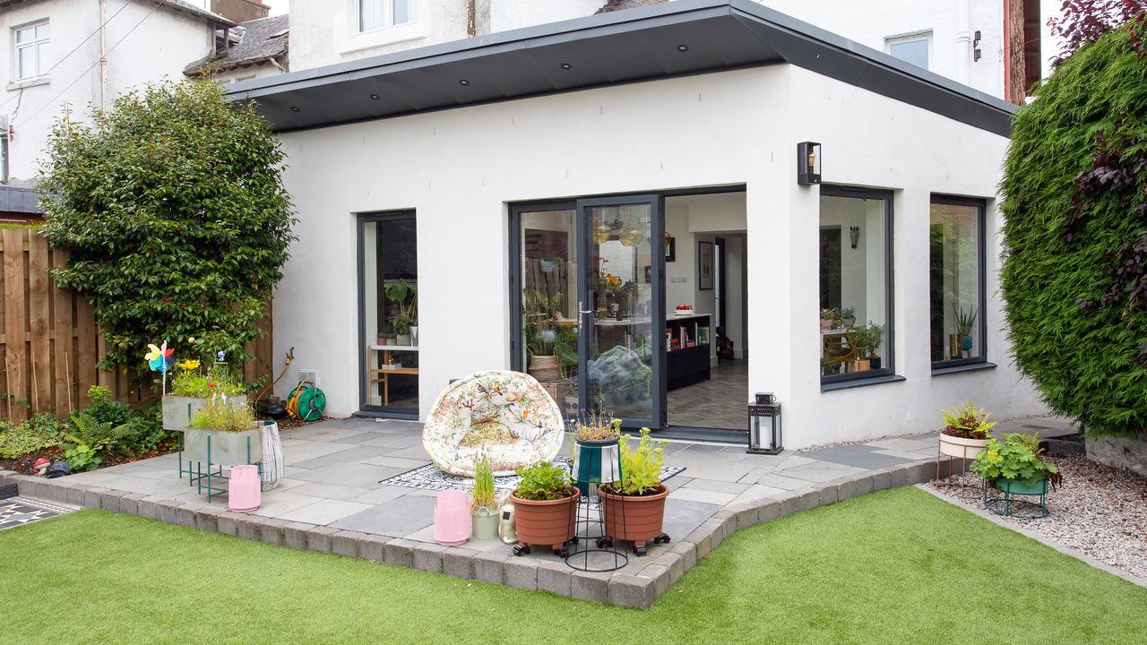 Single storey rear extension with white rendered walls and grey windows