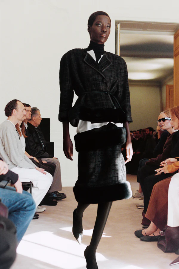 A model walking in the The Row show during the F/W 2026 show wearing a skirt suit.