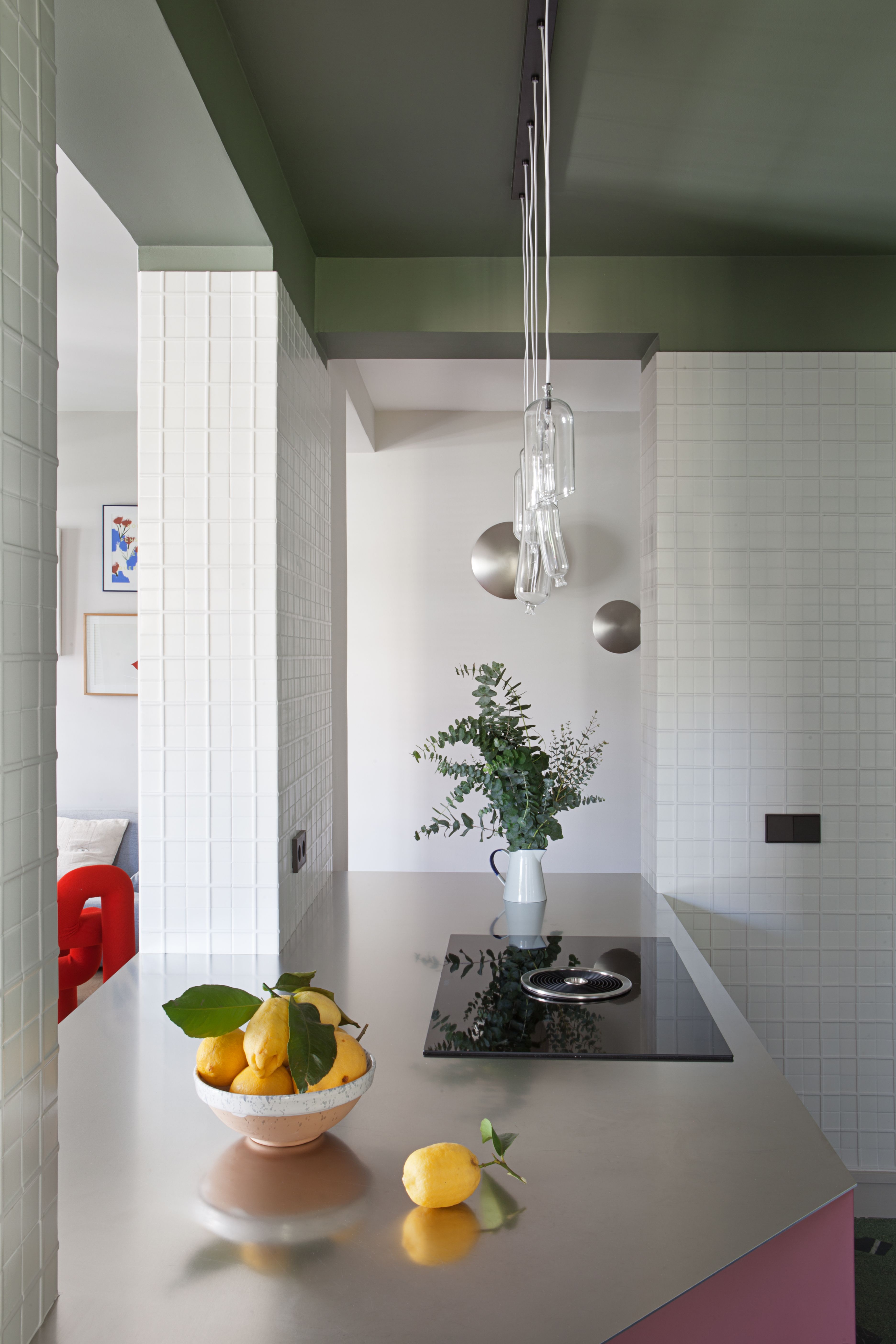 A kitchen with an angled top, a purple base and steel counter