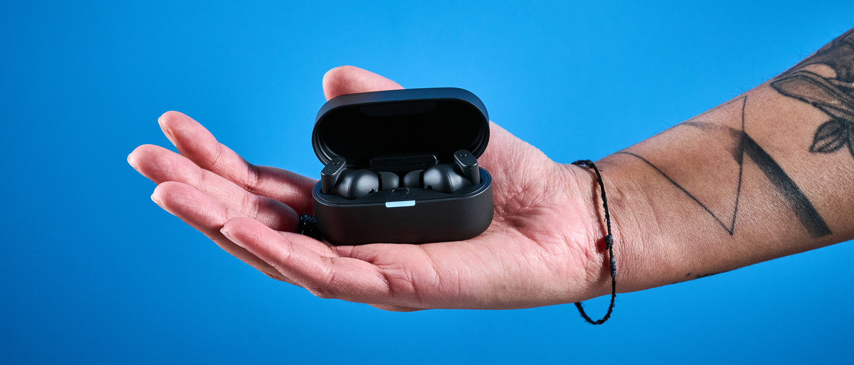 A pair of black Status Pro X wireless earbuds