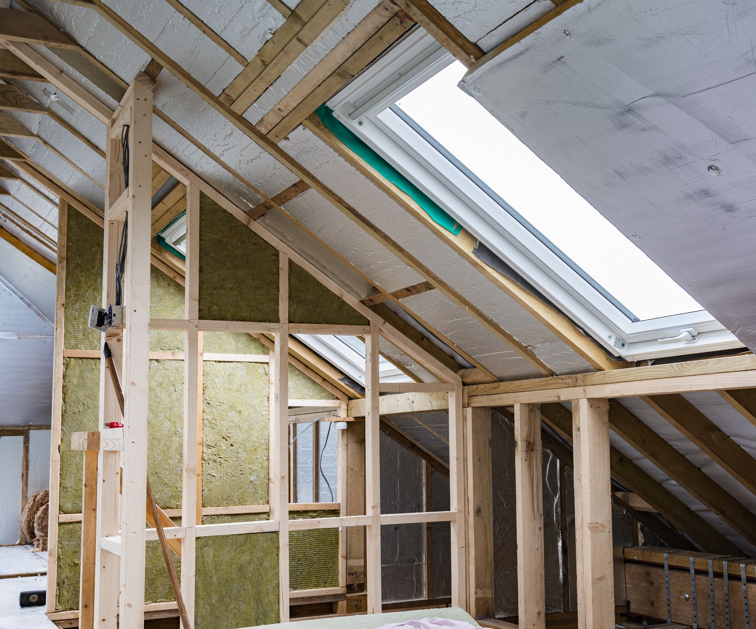 A sloped roof on a loft conversion with stud walls and insulation visible