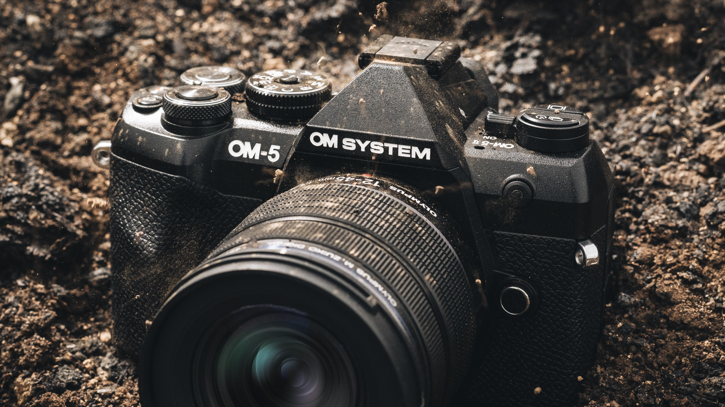 OM System OM-5 II camera caked in mud