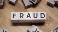 The word "fraud" spelled out in wooden blocks.