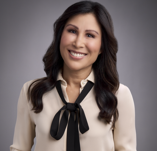 a woman with dark hair in a pale pink blouse