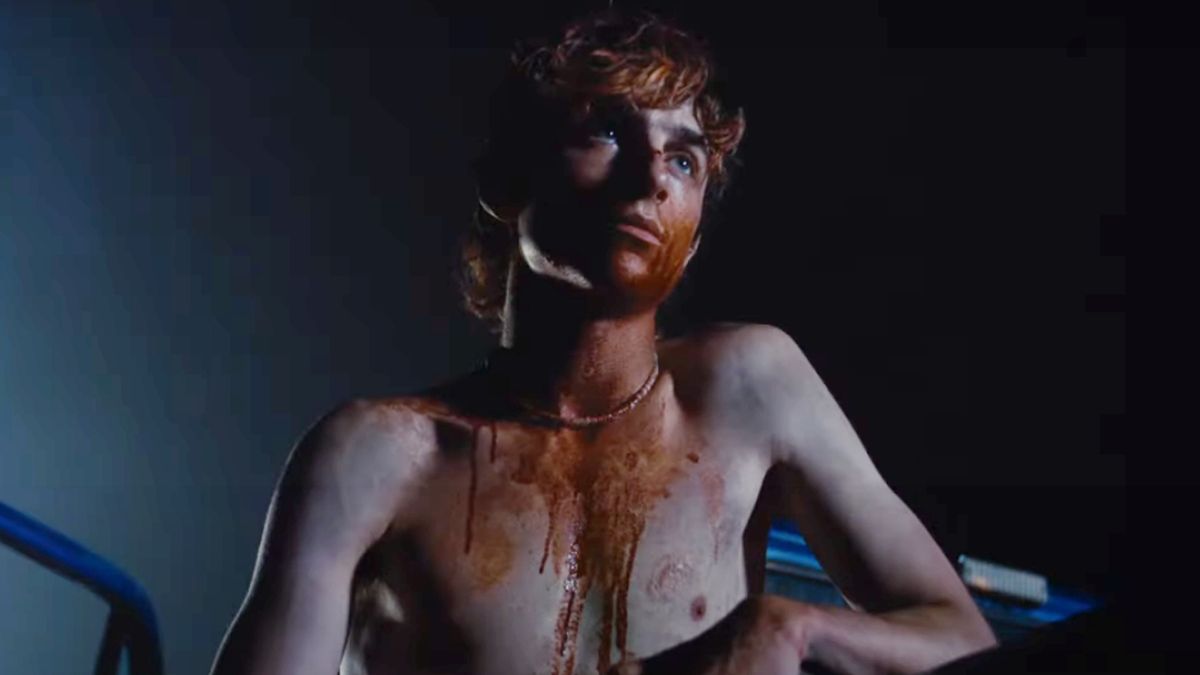 A Bloody Timothée Chalamet sits in a truck bed in Bones and All.