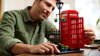 Lego Red London Telephone Box set being put into place by a man