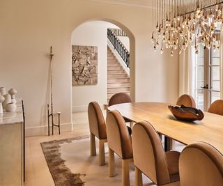 dining room with arched doorway to stairs and oval wood table and ornate chandelier