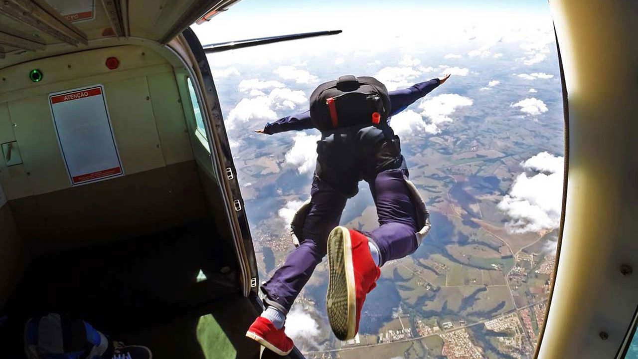 Man with parachute jumping out of a plane