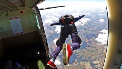 Man with parachute jumping out of a plane
