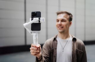 The Hohem iSteady V3 being held by a man who is vlogging.