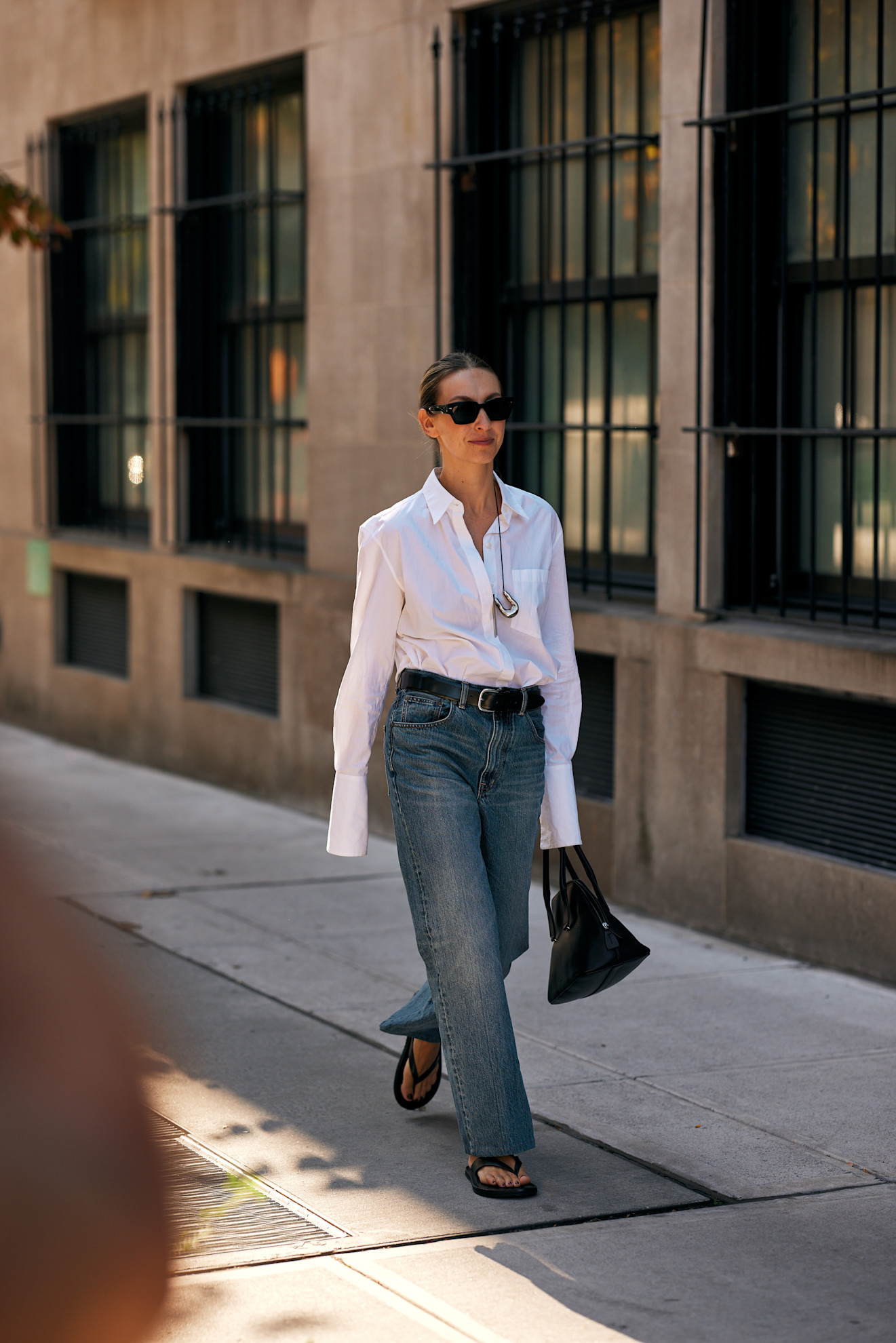 woman wearing button-down, jeans, and chunky sandals