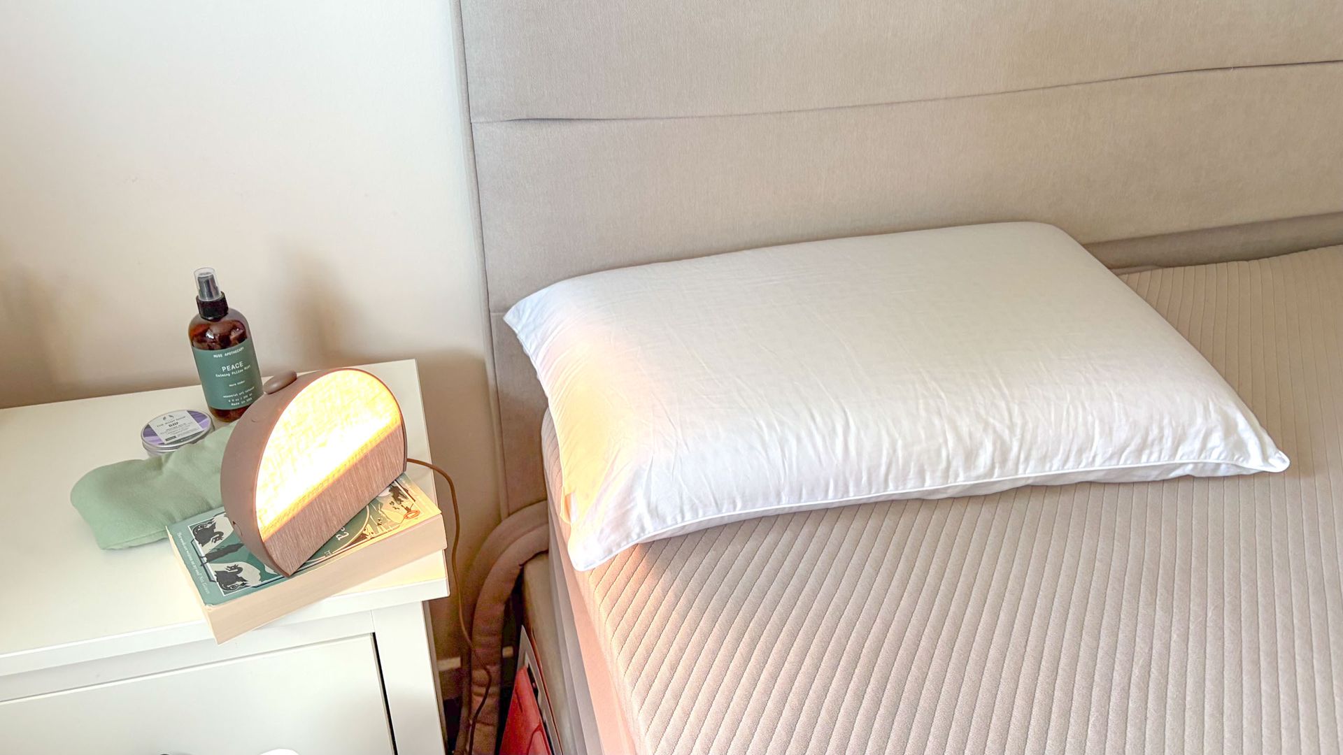 Bearaby SoftForm Pillow in white, next to a Hatch sunrise alarm clock