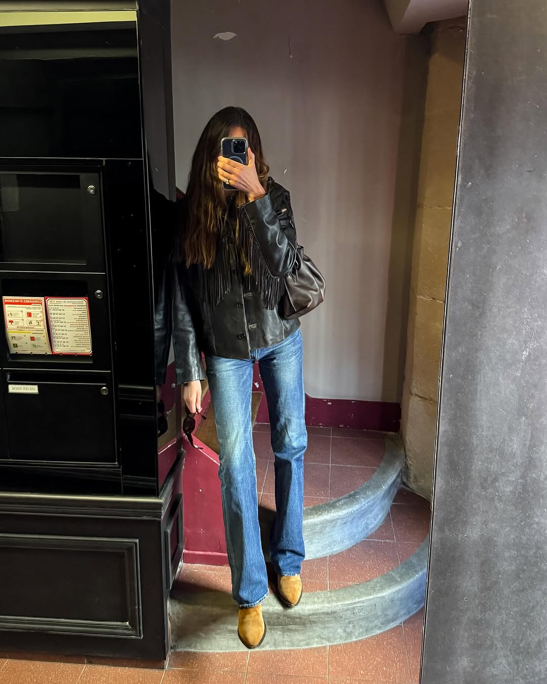 Woman wearing dark wash bootcut jeans fall 2025.