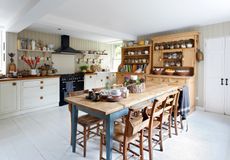 kitchen with wooden table, pantry and white cabinetry