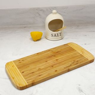 Clean wooden chopping board next to well of salt and lemon